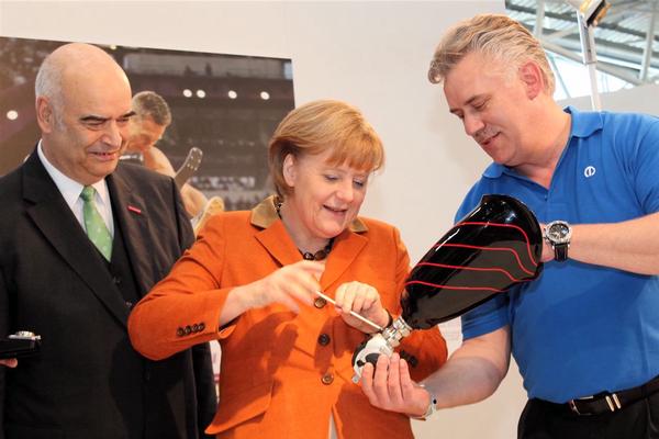 Handarbeit: Otto Kentzler, Prsident des ZDH, Bundeskanzlerin Angela Merkel und Klaus-Jrgen Lotz, Prsident des BIV fr Orthopdie-Technik.