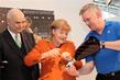 Handarbeit: Otto Kentzler, Prsident des ZDH, Bundeskanzlerin Angela Merkel und Klaus-Jrgen Lotz, Prsident des BIV fr Orthopdie-Technik.